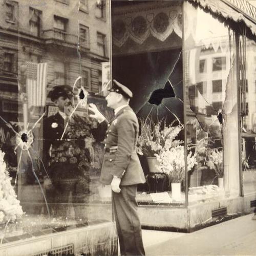 [Police officer examining Pelicano Rossi Floral Company bombed during  Longshoremen's Strike]