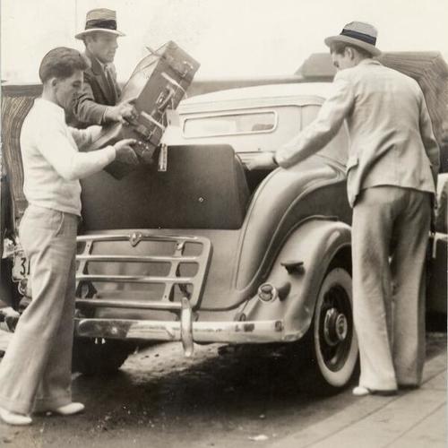 [Visitors to San Francisco loading luggage into a private automobile during general strike]