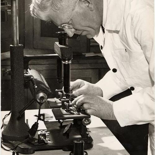[Francis X. Latulipe, Jr. looking through microscope]
