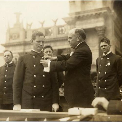 [Mayor James Rolph presenting medals to firemen at the Panama-Pacific International Exposition]