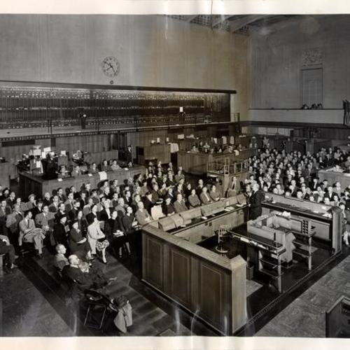 [Members of the public at an educational meeting at the San Francisco Stock Exchange]