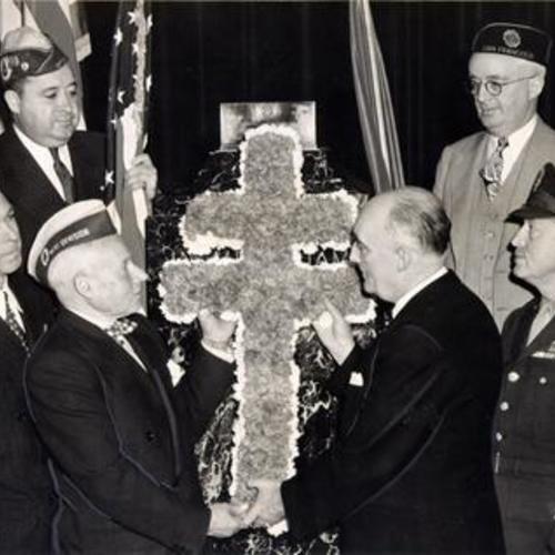 [French colony leaders and Legionnaires placing decorations on the memorial to the Unknown Soldier in the Veterans' War Memorial Building]