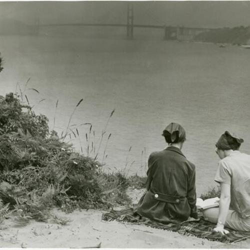 [Two women reading on a beach in Lincoln Park]