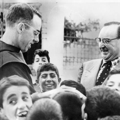 [Attorney General Edmund G. ("Pat") Brown talks with a Roman Catholic priest during his tour of Israel]