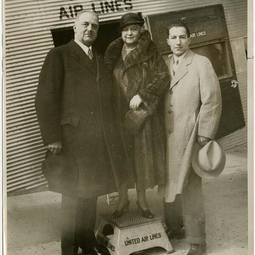 [Boarding an airplane are A.P. Giannini, Mrs. A.P. Giannini, and son]