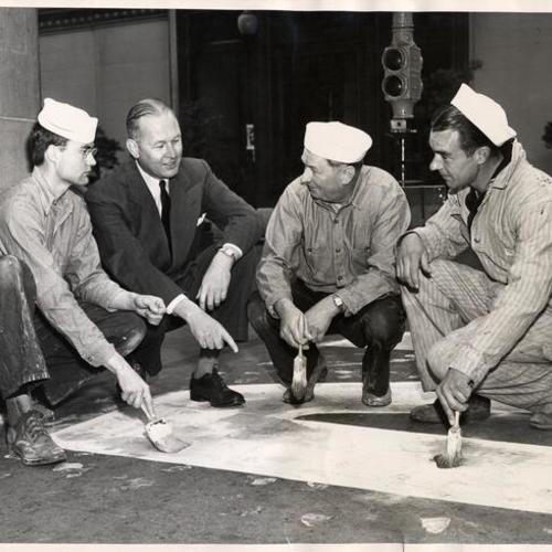 [Community Chest campaign Chairman Thomas G. McGuire with Naval Reserve Seabees Robert Goulder, Alois R. Hosp and E.C. Green painting the four foot white stripe running up the middle of Market Street from the Ferry Building that will record the progress o