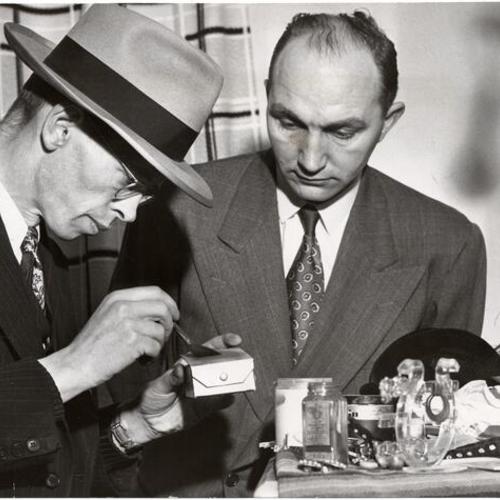 [Officers Pat Walsh and Leonard Wiebe of the San Francisco Police Department dusting for fingerprints at the scene of a crime]