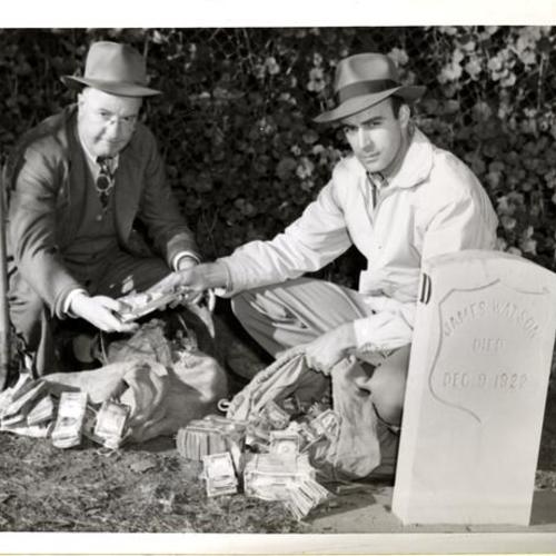 [Law enforcement officers finding stolen money buried by two bandits who had robbed a Los Angeles bank messenger]