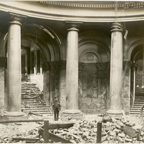 [Unidentified man standing inside the City Hall rotunda after the earthquake and fire of 1906]