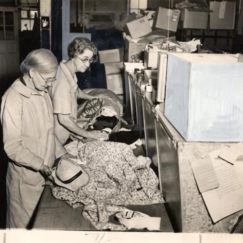 [Two women workers sorting contributions at Community Chest agency Goodwill Industries]