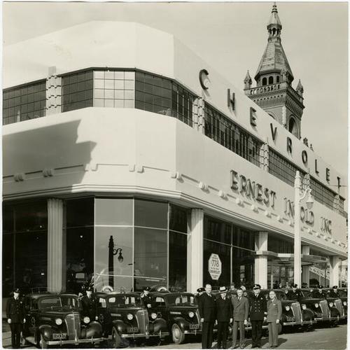 [Representatives of Ernest Ingold Chevrolet dealership posing with Chief of Police William J. Quinn and city purchasing agent T. A. Brooks in front of a groups of cars sold to the San Francisco Police Department]