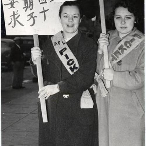[Two striking 5 & 10 cent store workers holding picket signs written in Chinese and Italian]