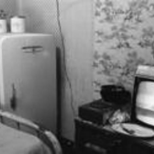 [Refrigerator, cooktop, and television at foot of bed in Daton Hotel, Lee Washington's room]