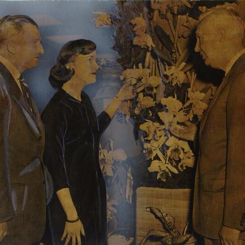 [Edward Goeppner, Ernest L. Malloy and June Dietz looking at a floral display from Macy's annual Easter Flower Week exhibit]