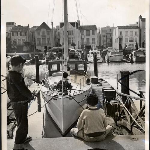 [Two youths looking at the yacht Sovereign at Yacht Harbor, Marina District]