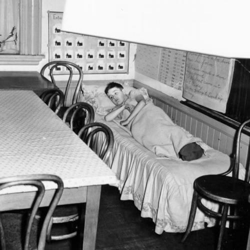[Unidentified student resting in room next to principal's office at Fremont Elementary School]