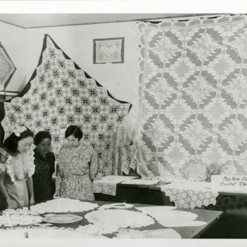 [Japanese American women at a crochet display they created at Topaz War Relocation Center in Utah]