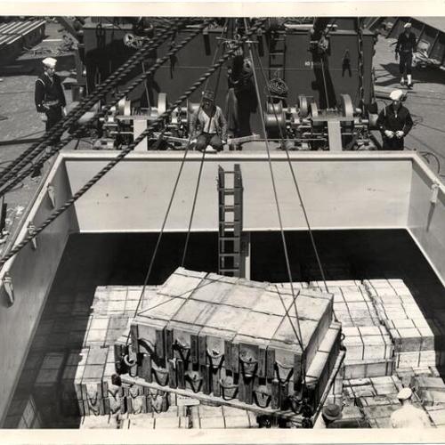 [Anti-aircraft ammunition being loaded onto a vessel]