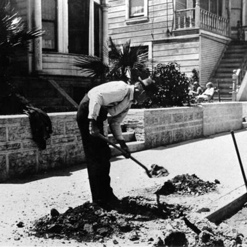 [Man shoveling dirt, onto the side walk, on Girard street]