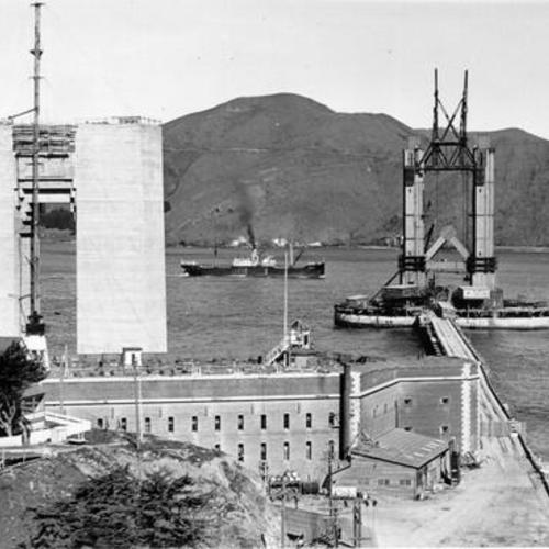 [Construction photo of south tower of Golden Gate Bridge with completed north tower in background]