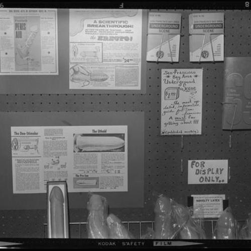 Interior view of peg board display with dildos, advertisements and pamphlets