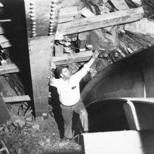 [Bill Connelly, tunnel superintendent, inspecting inside the tunnel on Yerba Buena Island during San Francisco-Oakland Bay Bridge construction]