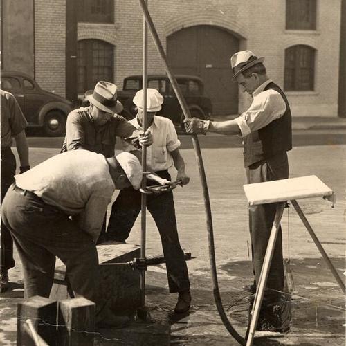 [WPA workmen drilling the pavement to determine the nature of the soil below for San Francisco's subway system]