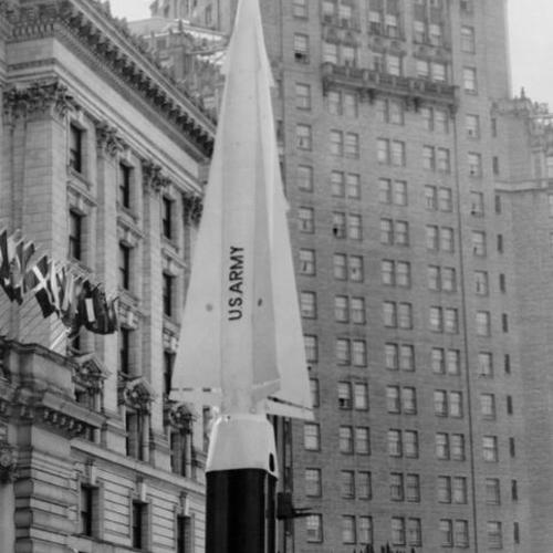[U. S. Army rocket on display in front of the Fairmont Hotel with the Mark Hopkins Hotel in background]