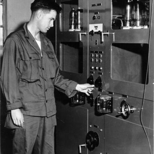 [Sgt. Joyce Hunter standing before a transmitter at the Sixth Army's Communication Center in the Presidio]