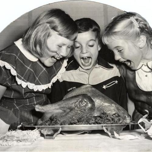 [Sally Harbison and two visitors from Edgewood Orphanage admiring a Thanksgiving turkey]