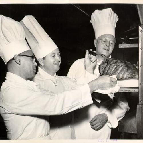 [Guest chefs helping to prepare a roast beef in the kitchen at Mount Zion Hospital]