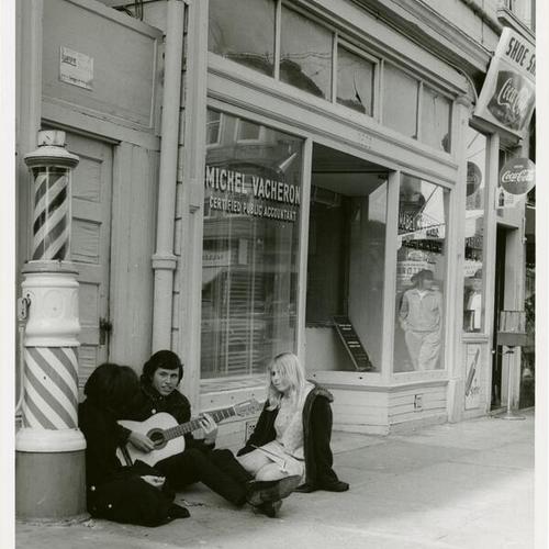[Haight Ashbury -  musician playing to a two member audience]
