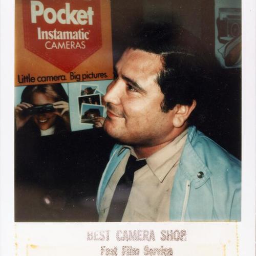 [Ellen's father Oscar posing for a portrait at a camera shop]
