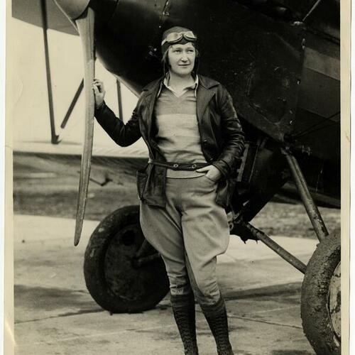 Maxine Dunlap standing in front of plane with hand on propeller