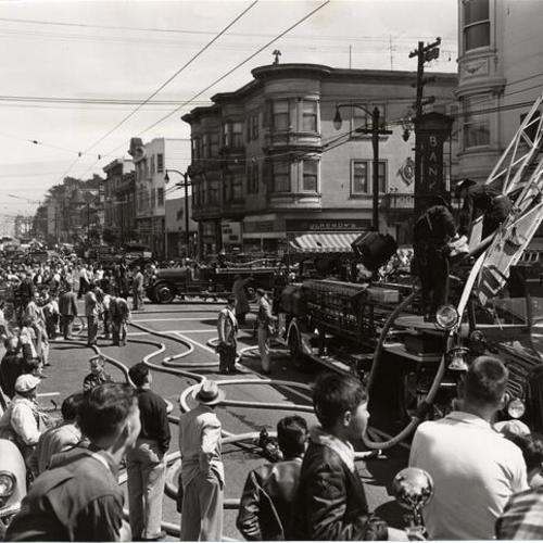 [Firemen fighting a three-alarm fire in an apartment building at Haight and Ashbury streets]