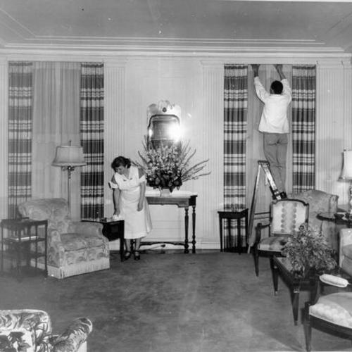 [Employees of the St. Francis Hotel tidying up the main sitting room of the presidential suite for General Douglas MacArthur]