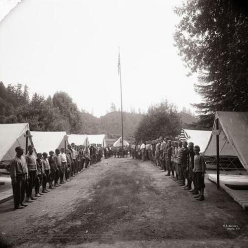 People gather in front of tents outside at Camp McCoy