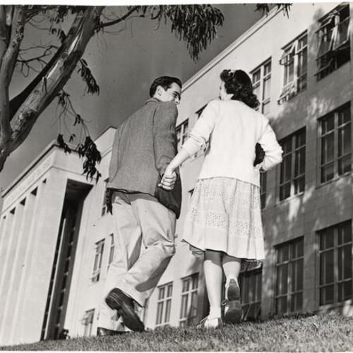 [Couple holding hands on the campus of San Francisco Junior College]