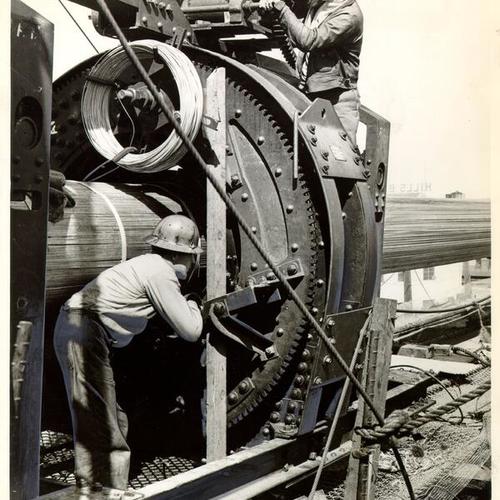 [Men working with cables during construction of the San Francisco-Oakland Bay Bridge]