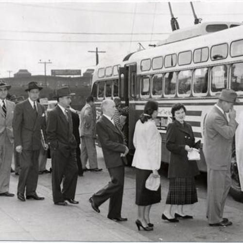 [Commuters lined up to board a Muni bus at the Southern Pacific Depot]