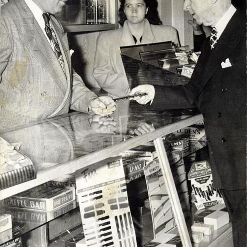 [Tom Brooks purchasing a candy bar from William Peck at the cigar stand in City Hall]