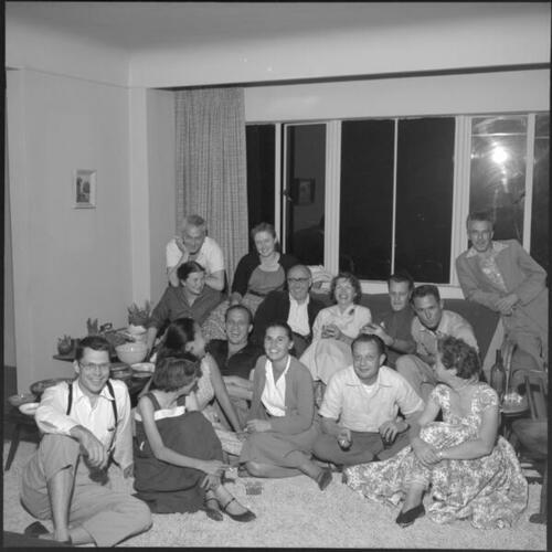 Group portrait of people sitting in living room