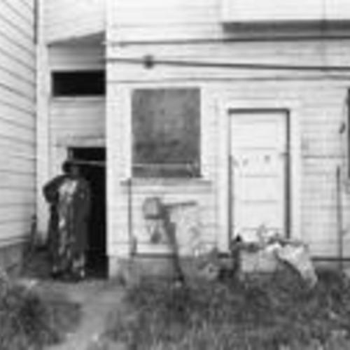 [Unnamed woman stands in the doorway to the backyard of a Fillmore Street house that is part of Western Addition redevelopment]
