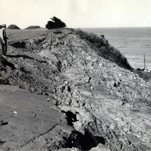 [John McLaren surveying a section of road that slid away at Lands End]