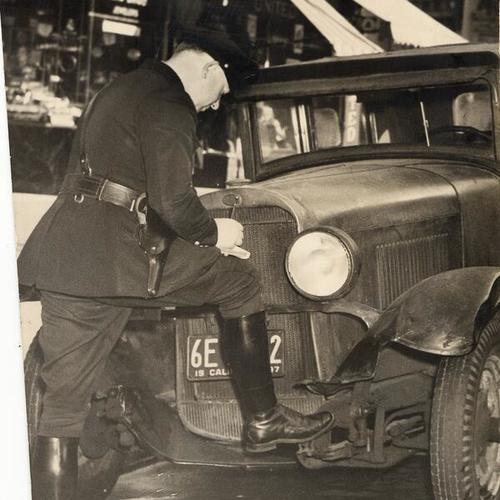 [Officer Tom Miller making out the first "no parking" tag]