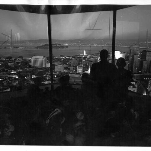 [Night view of people looking at the bay and San Francisco-Oakland Bay Bridge from Top of the Mark Skylounge]