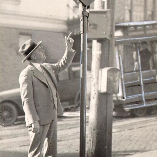[Unidentified man pointing at a cable car stop signal]
