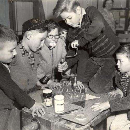 [Columbia Park Boys Club members Edward Arana, Carl C. Rissnann, David Diamond, Louis Felder and Tommy Reiche working on a checker board]