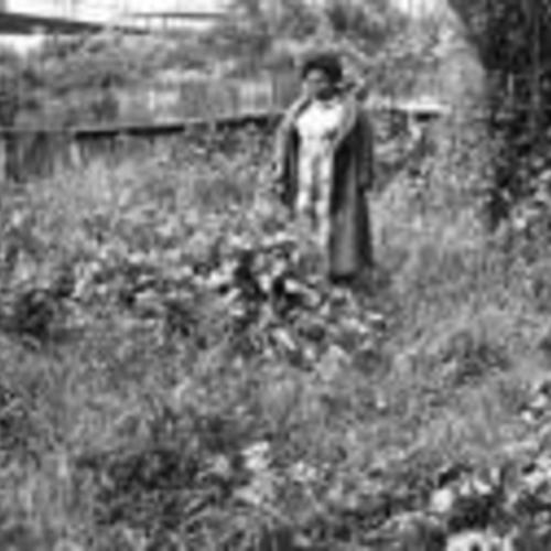 [Unnamed woman stands in the backyard of a Fillmore Street house that is part of Western Addition redvelopment]