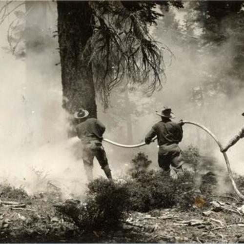 [Workers for the Forest Conservation Corps using pumps to fight fires]